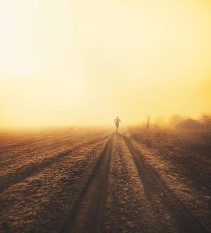 An athlete running on a sunrise trail, symbolizing discipline and spiritual journey.