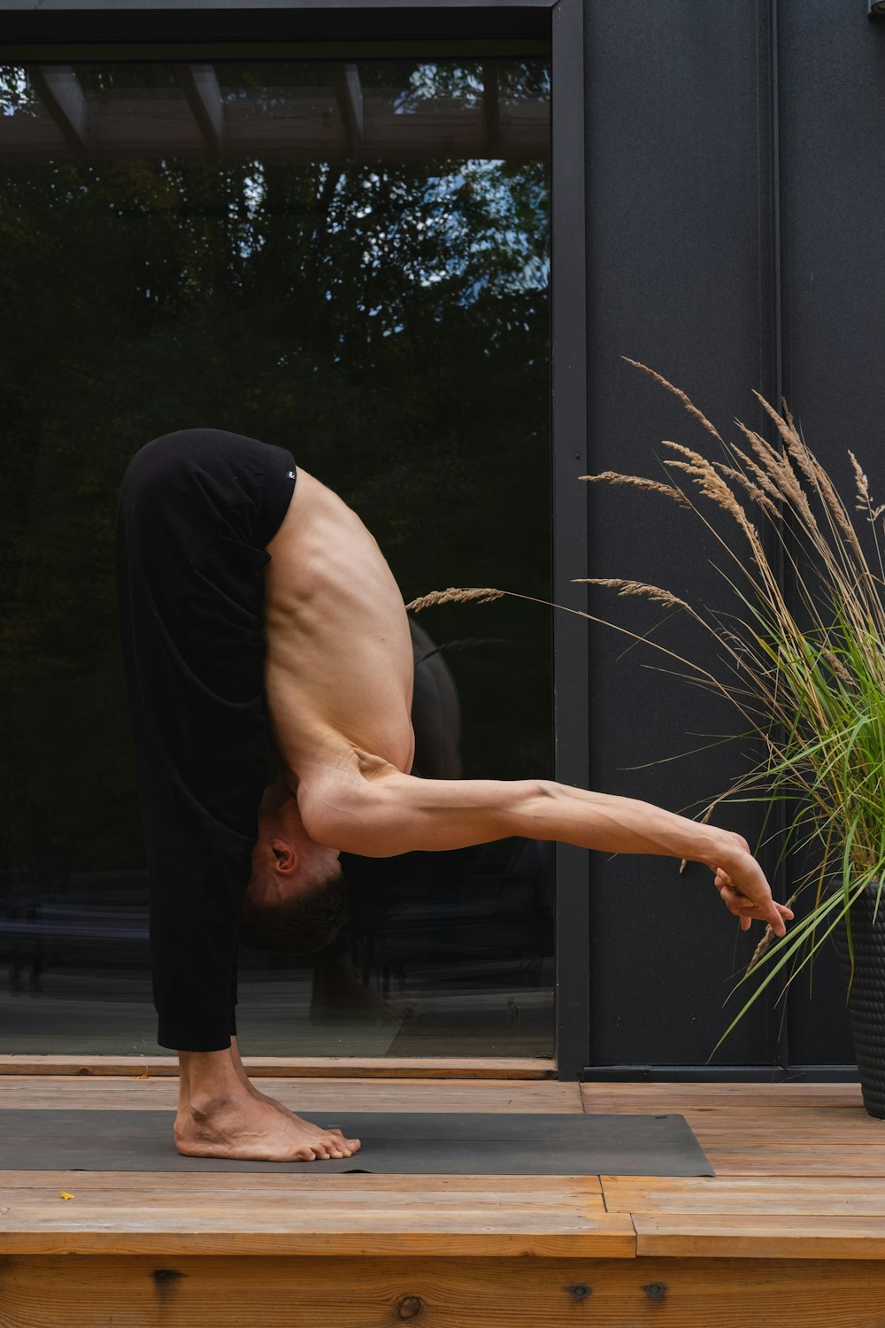 a man doing a handstand on a yoga mat