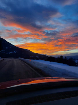 A winding mountain road with a sunset backdrop.