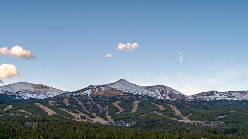 the mountains are covered in snow and trees