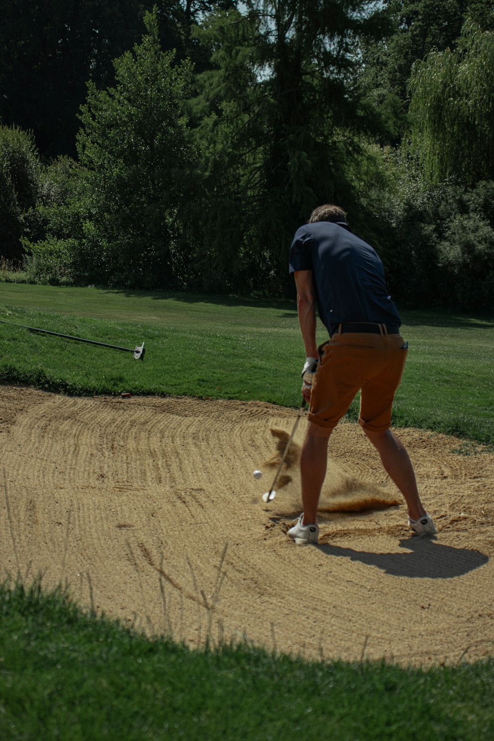 a man is playing golf on a dirt course