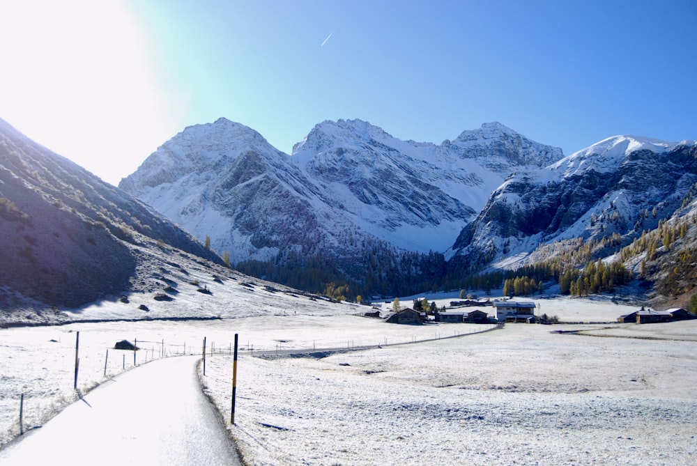 a snow covered mountain range with a road in the foreground