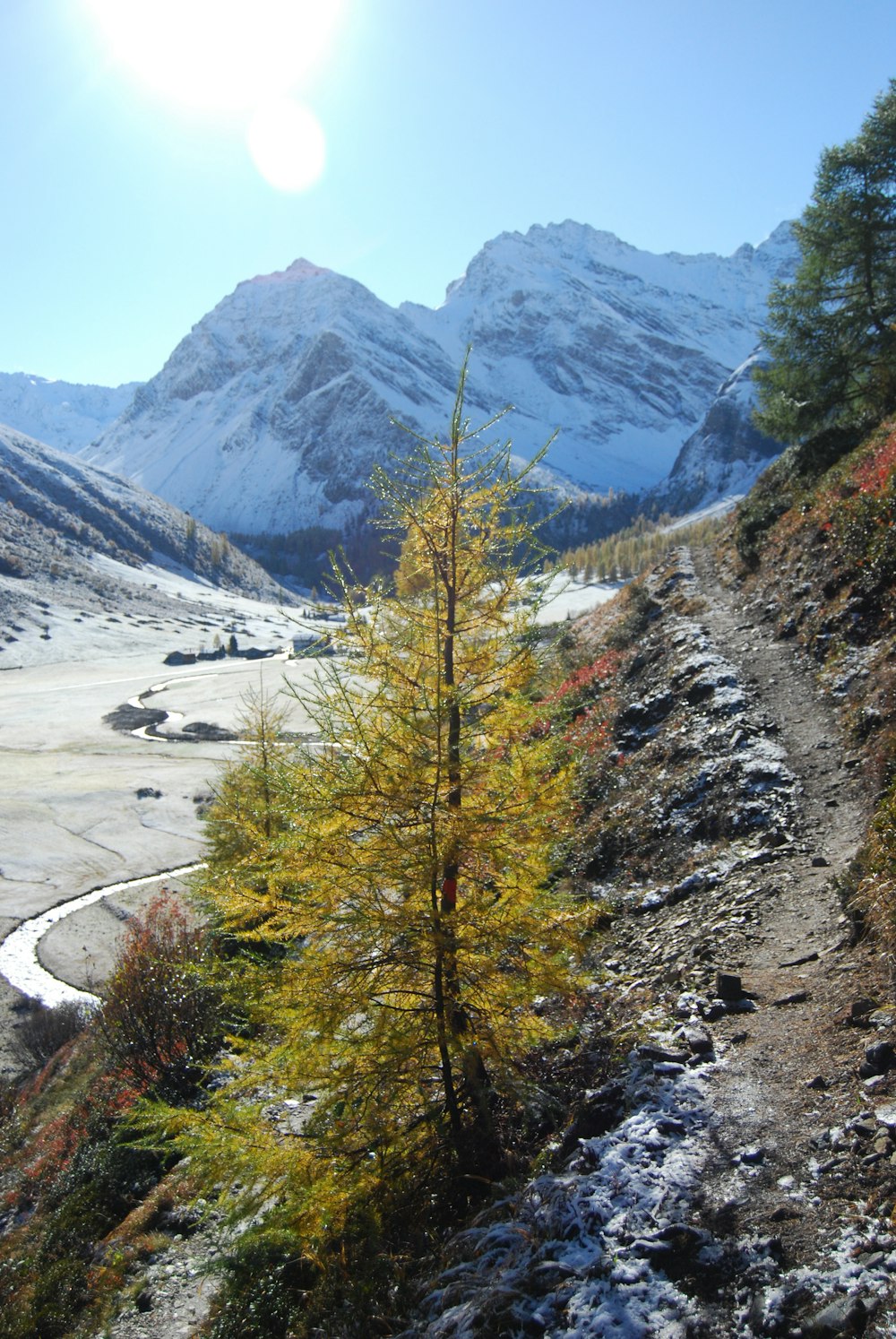 a trail in the mountains with snow on the ground