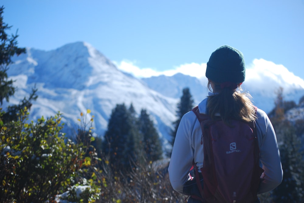 a person with a backpack looking at a mountain