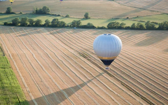 A hot air balloon casting a shadow over a peaceful countryside