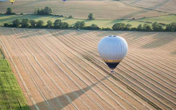 A hot air balloon casting a shadow over a peaceful countryside