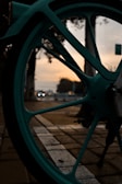 Artistic shot of a bike wheel spinning, capturing motion blur against a sunset.