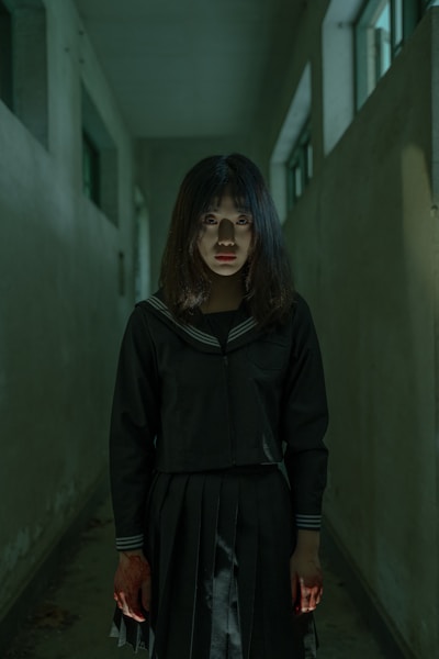a woman standing in a hallway with a creepy look on her face