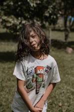 a young girl standing in a field with a frisbee