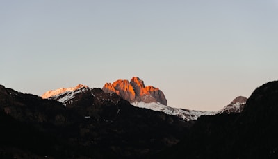 A serene mountain range bathed in golden sunrise light.