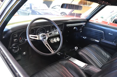 Interior view showing custom-installed performance gauges and bold checkered-flag accents inside a Camaro.