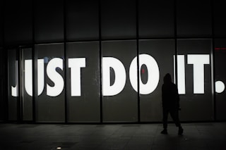 a person standing in front of a sign that says just do it