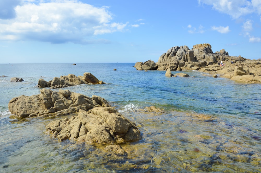 a body of water with rocks in the middle of it