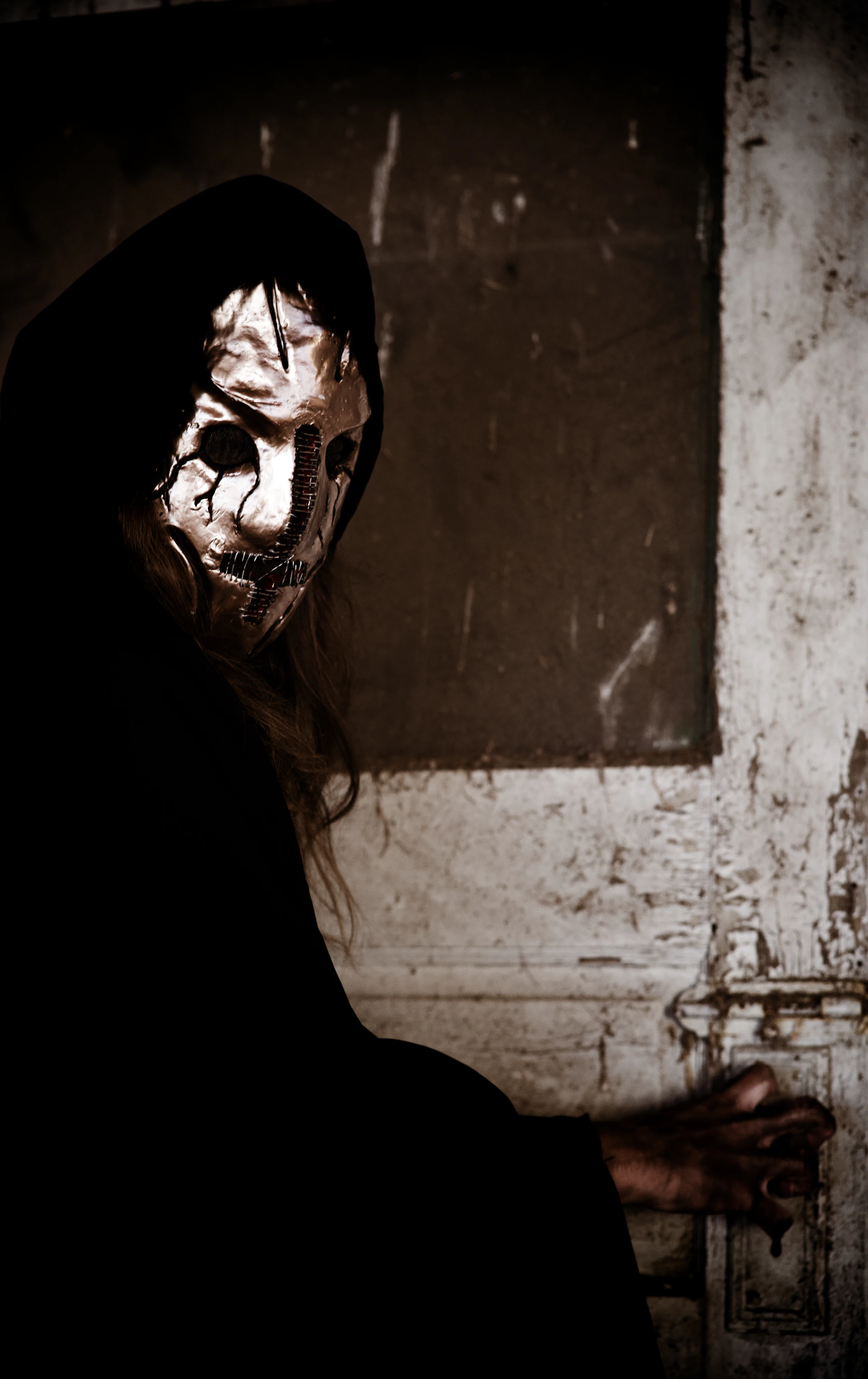 a man in a black hoodie with a mask on