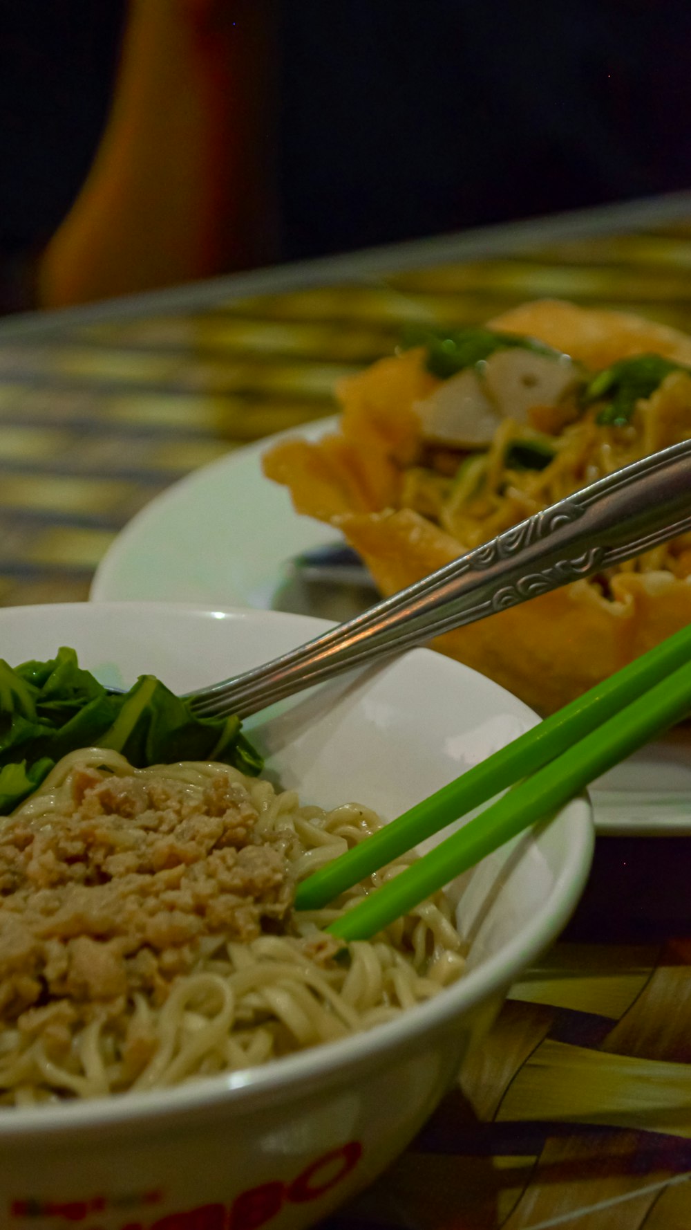 a close up of a bowl of food with chopsticks