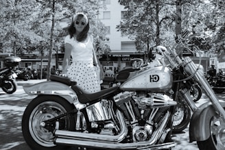 a woman standing next to a parked motorcycle