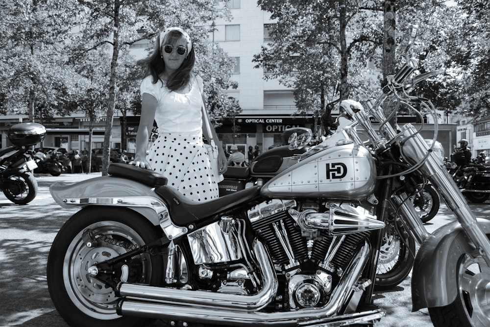 a woman standing next to a parked motorcycle