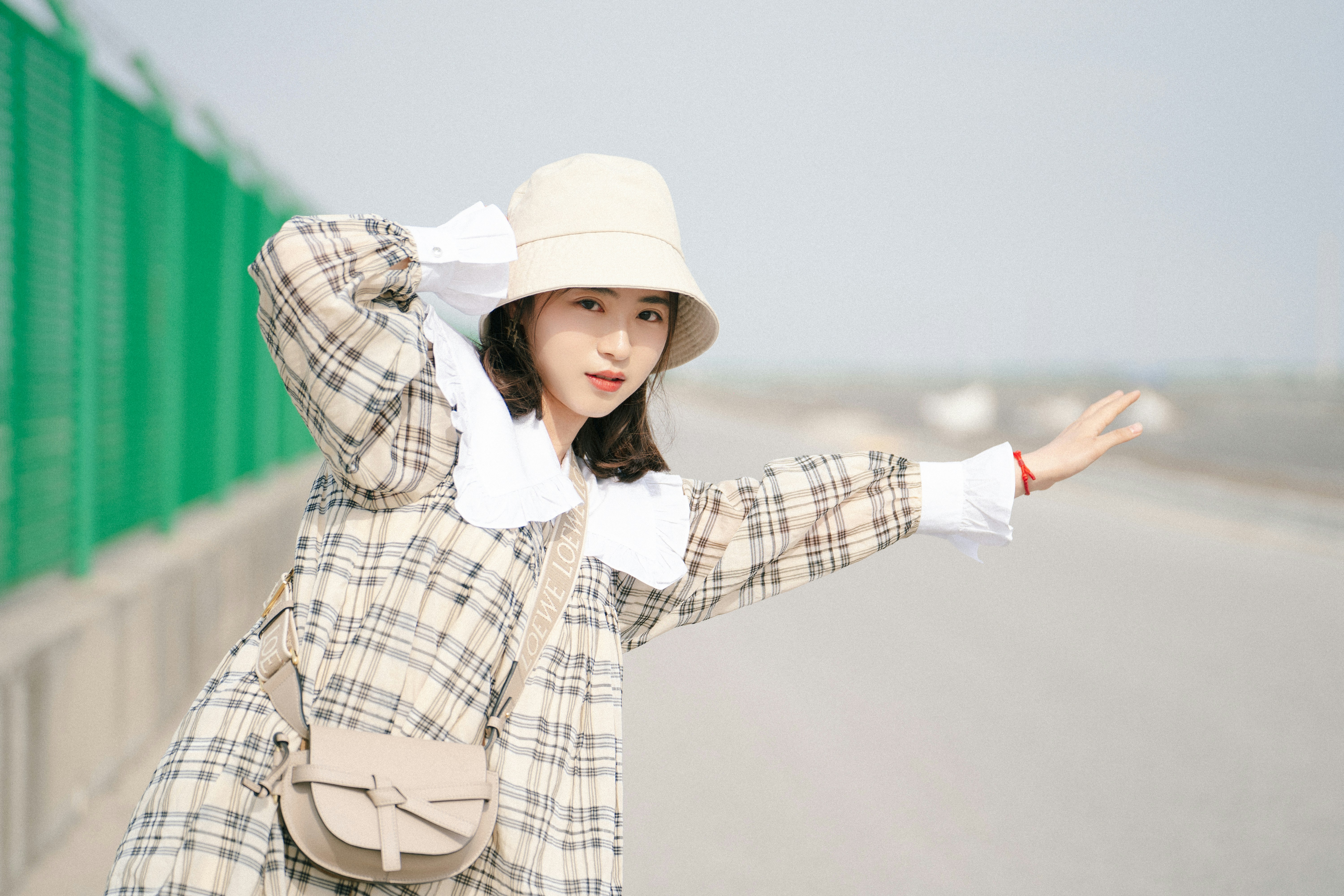 a woman wearing a hat and a plaid coat