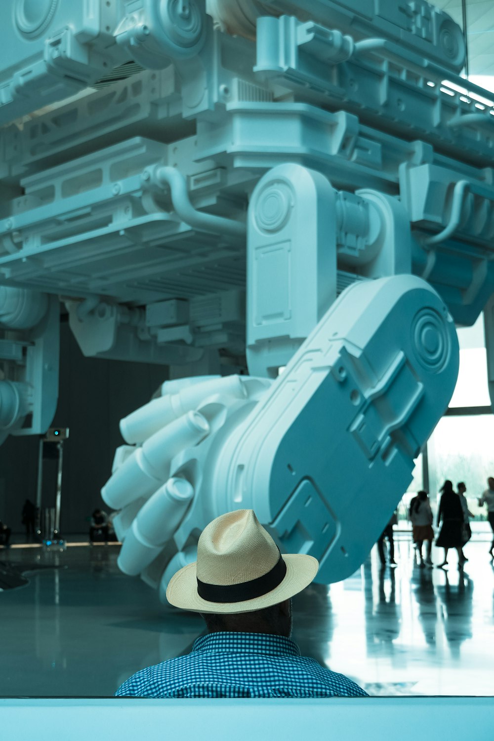a man in a hat looking at a large machine