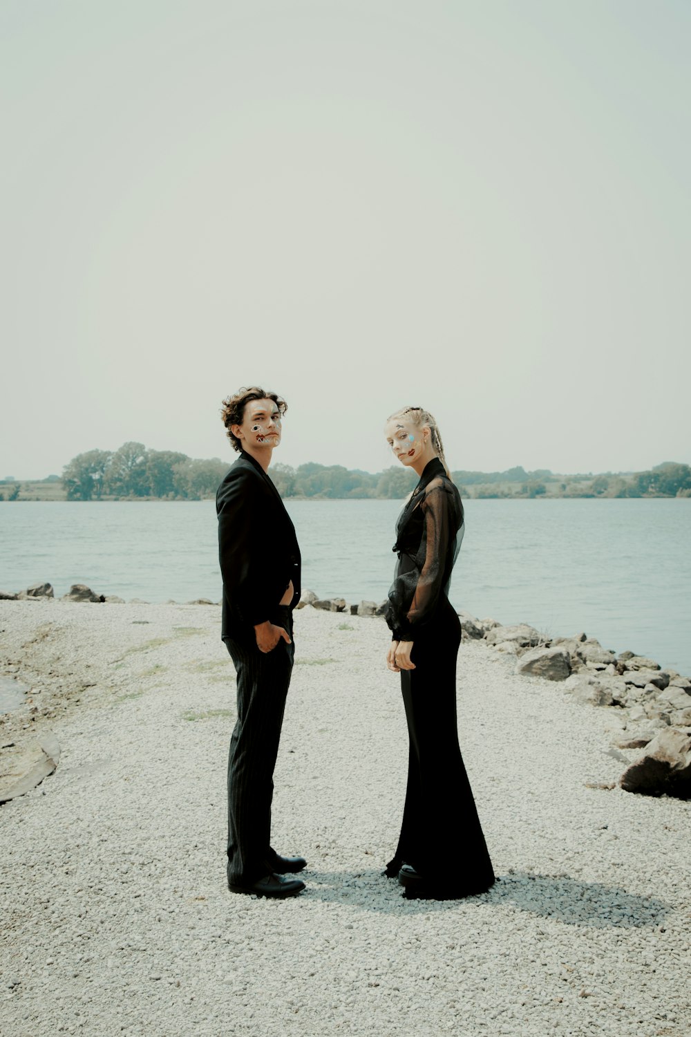 a man and a woman standing next to each other on a beach