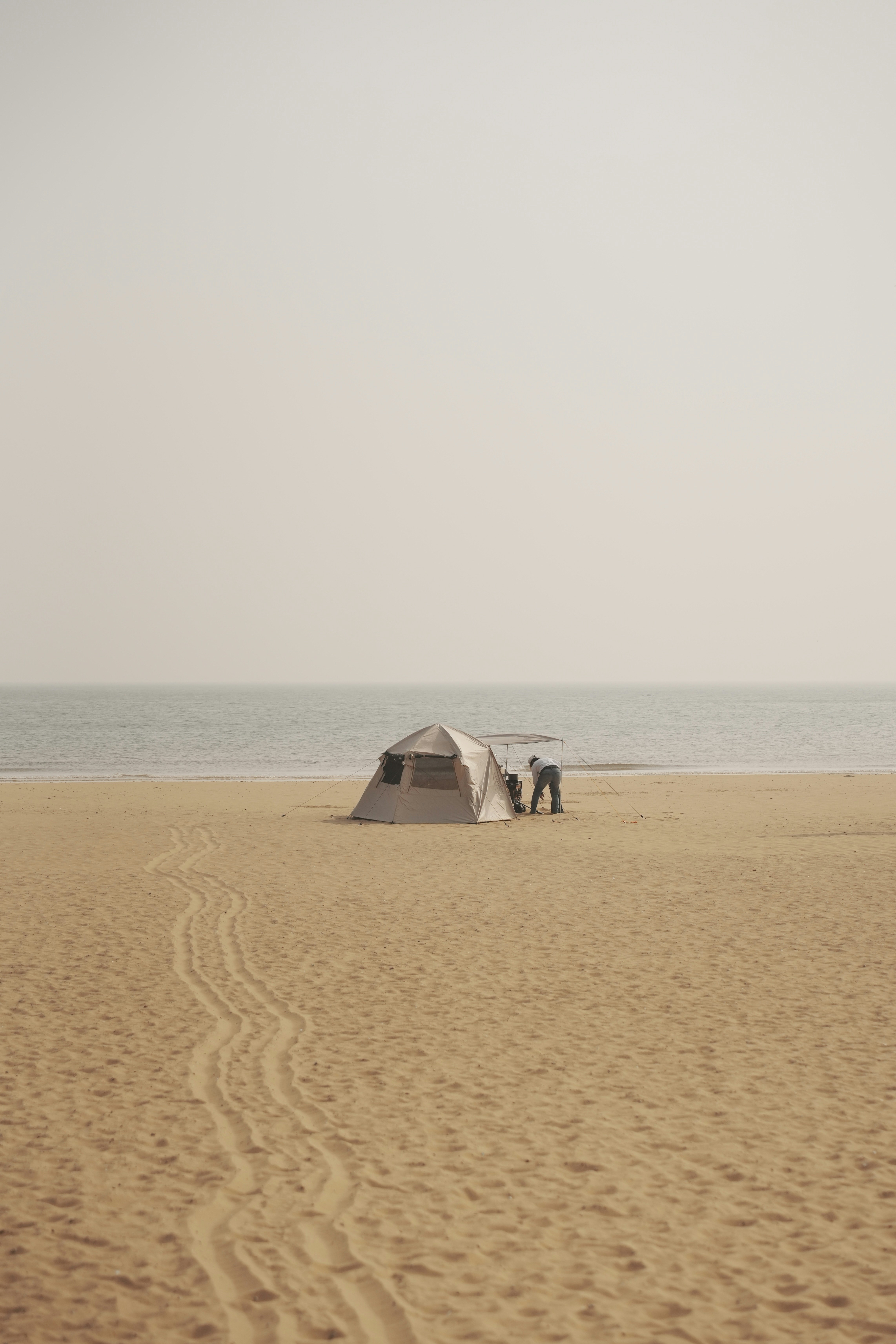 모래 사장 위에 앉아있는 두 개의 텐트