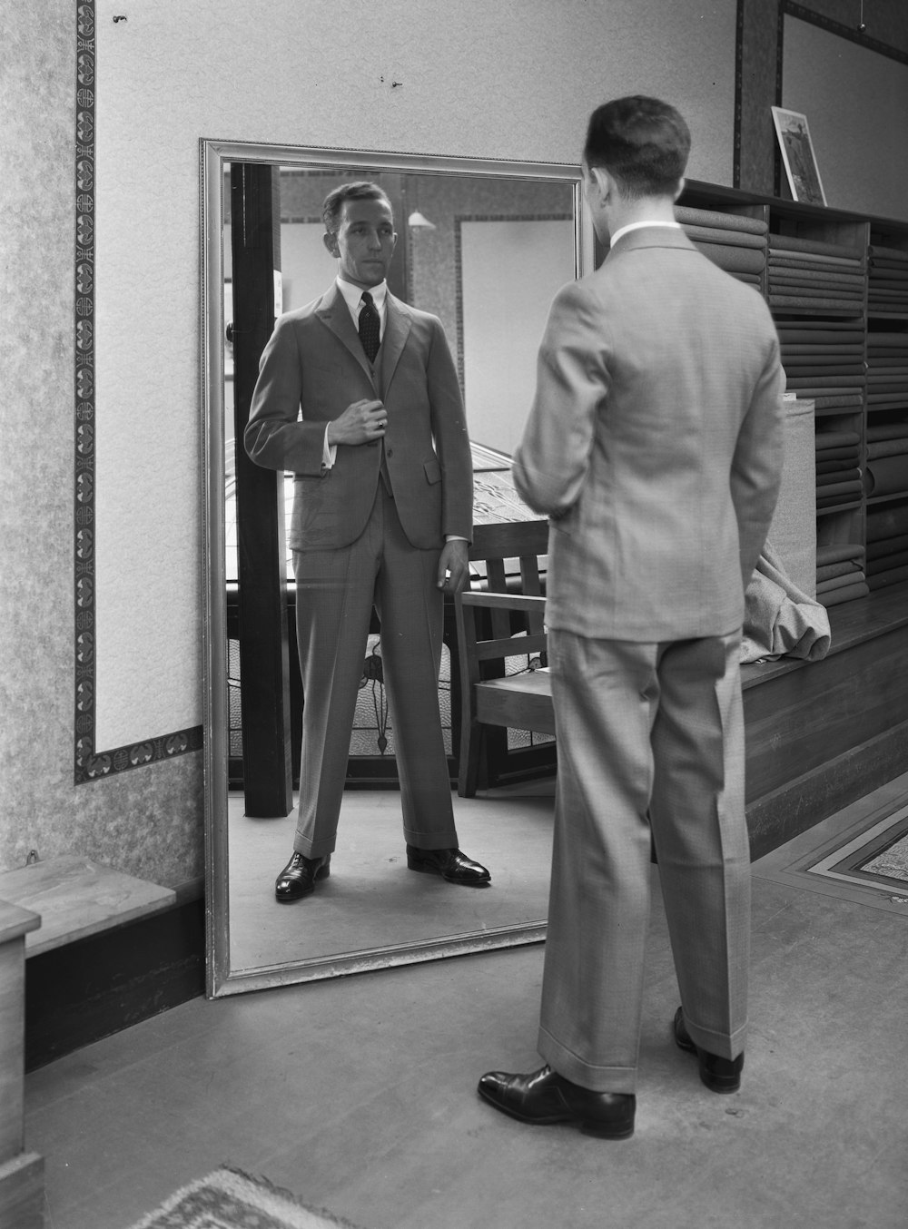 a man in a suit looking in a mirror