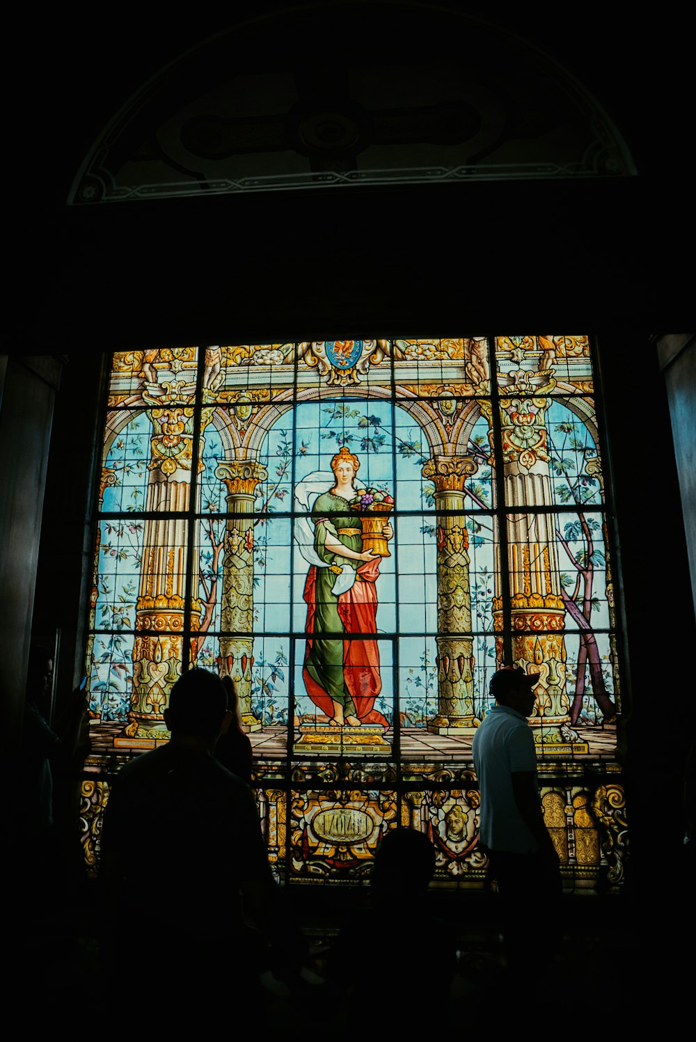 people standing in front of a stained glass window