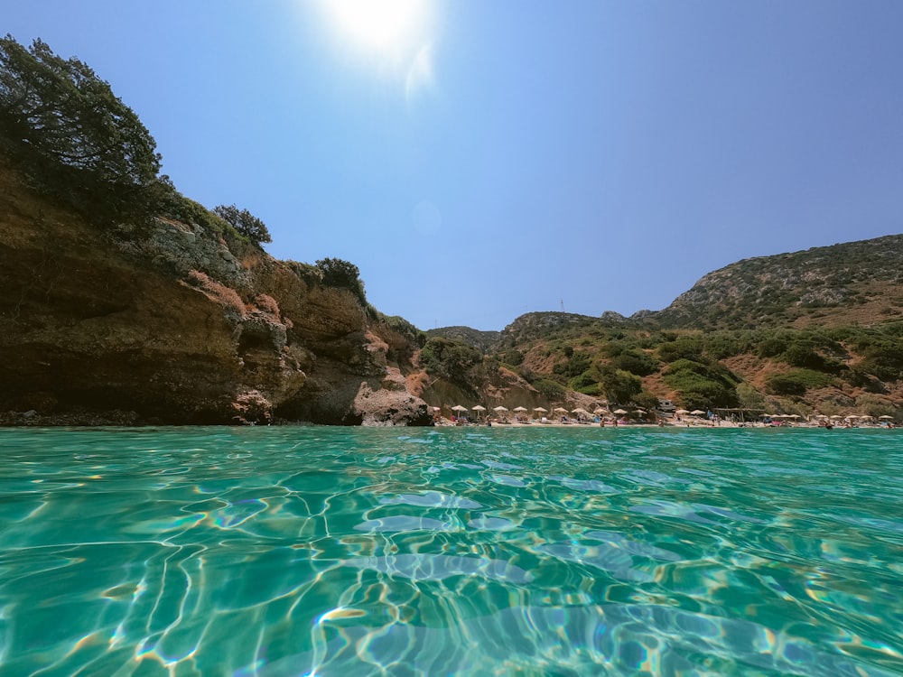 a body of water with a cliff in the background