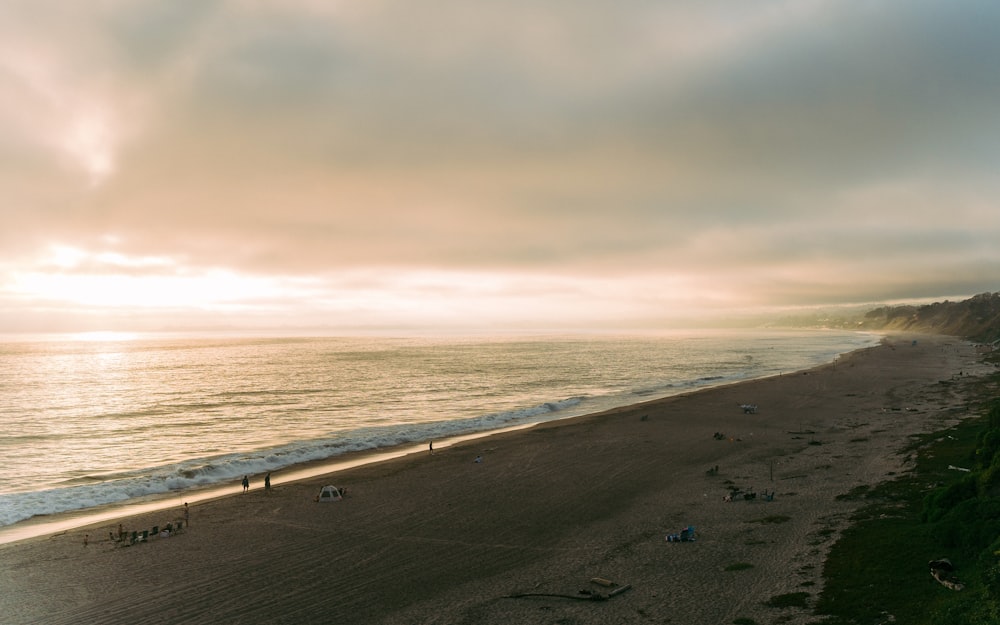 a group of people standing on top of a sandy beach