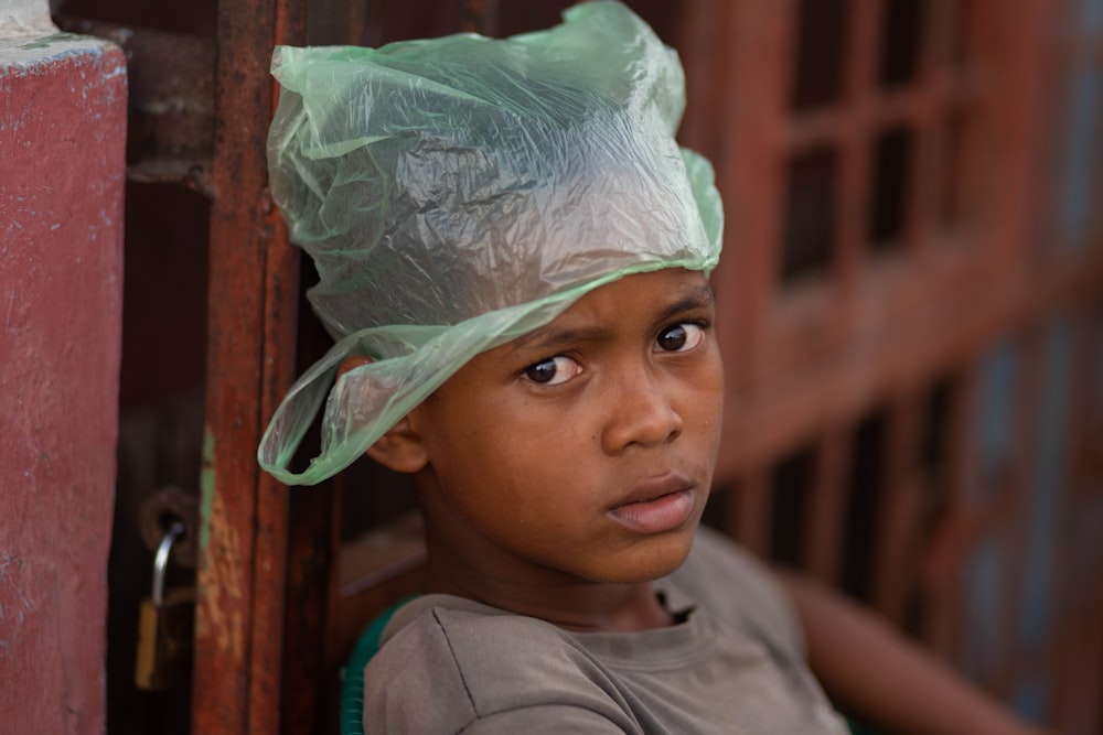 a young boy wearing a plastic bag on his head