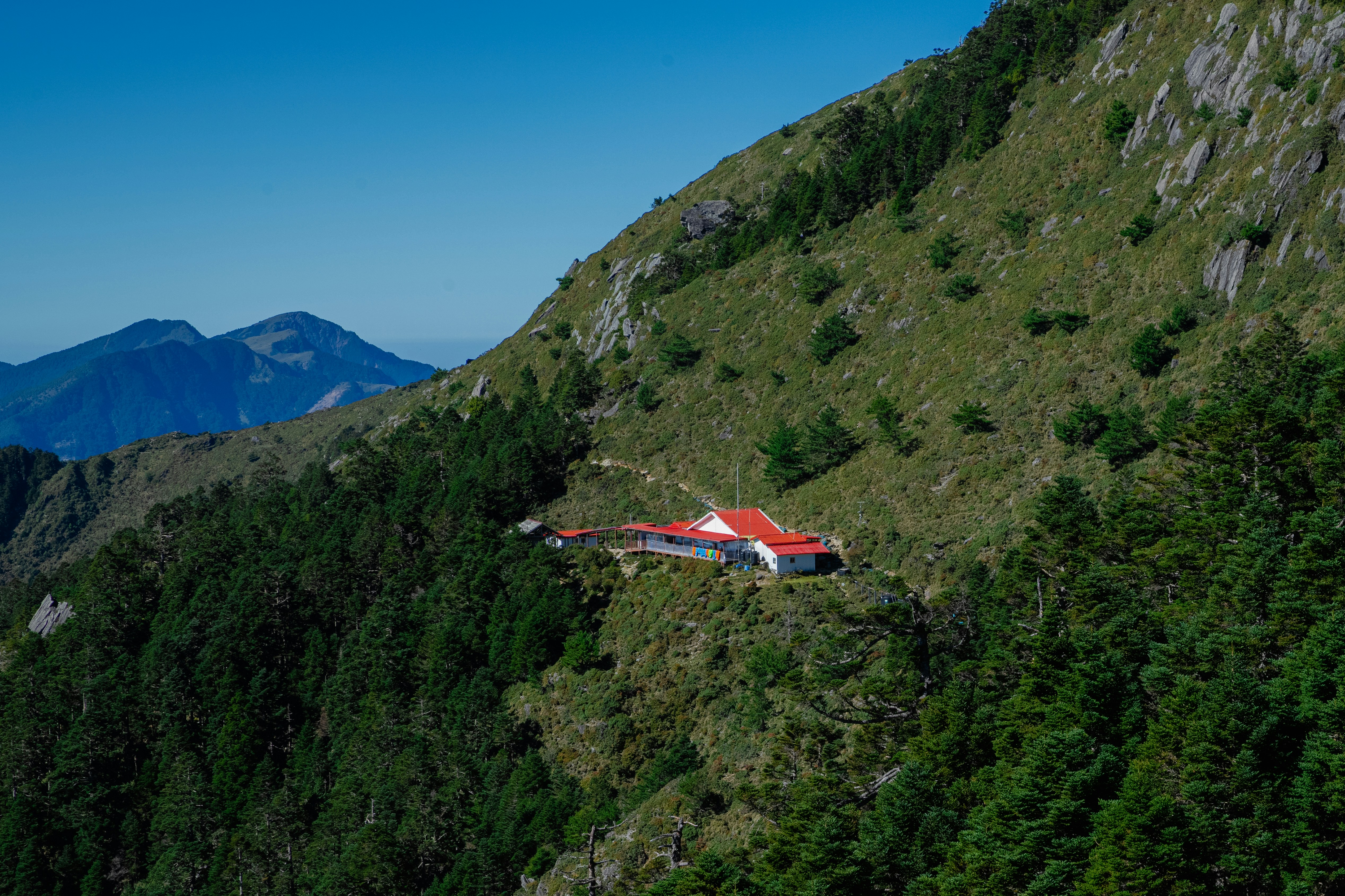 a house on the side of a mountain surrounded by trees