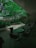 A peaceful indoor courtyard features green trees and plants, surrounded by a modern building. There are several empty tables and chairs, creating a serene setting for relaxation or conversation.