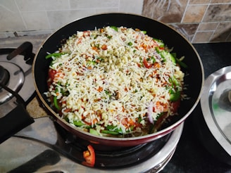 A rustic cast iron skillet sizzling with colorful vegetables on a stovetop.