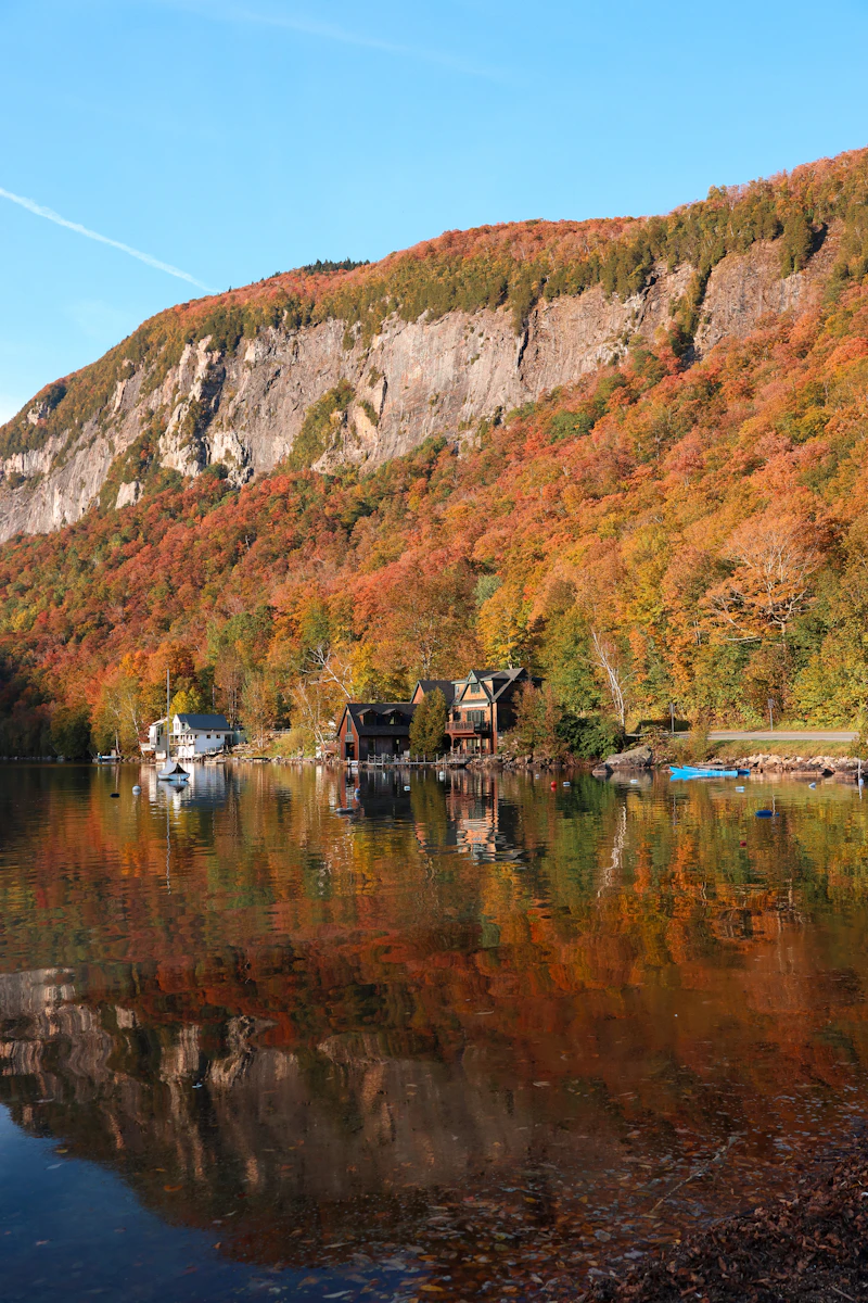 A forested hillside reflected in a still Vermont lake