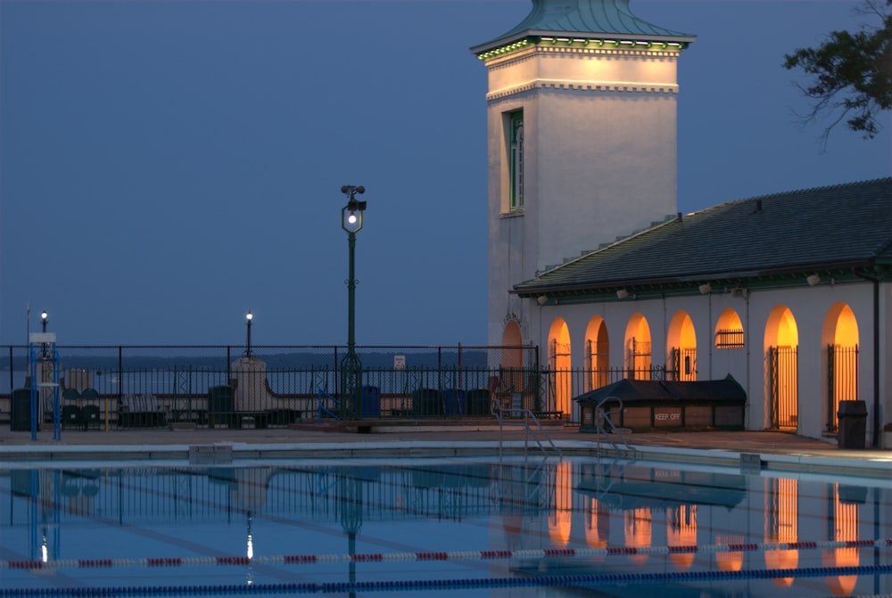 a building with a clock tower next to a swimming pool