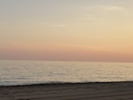 A peaceful beach scene with gentle waves and a pastel sunset.