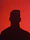 a silhouette of a man in front of a red background