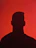 a silhouette of a man in front of a red background