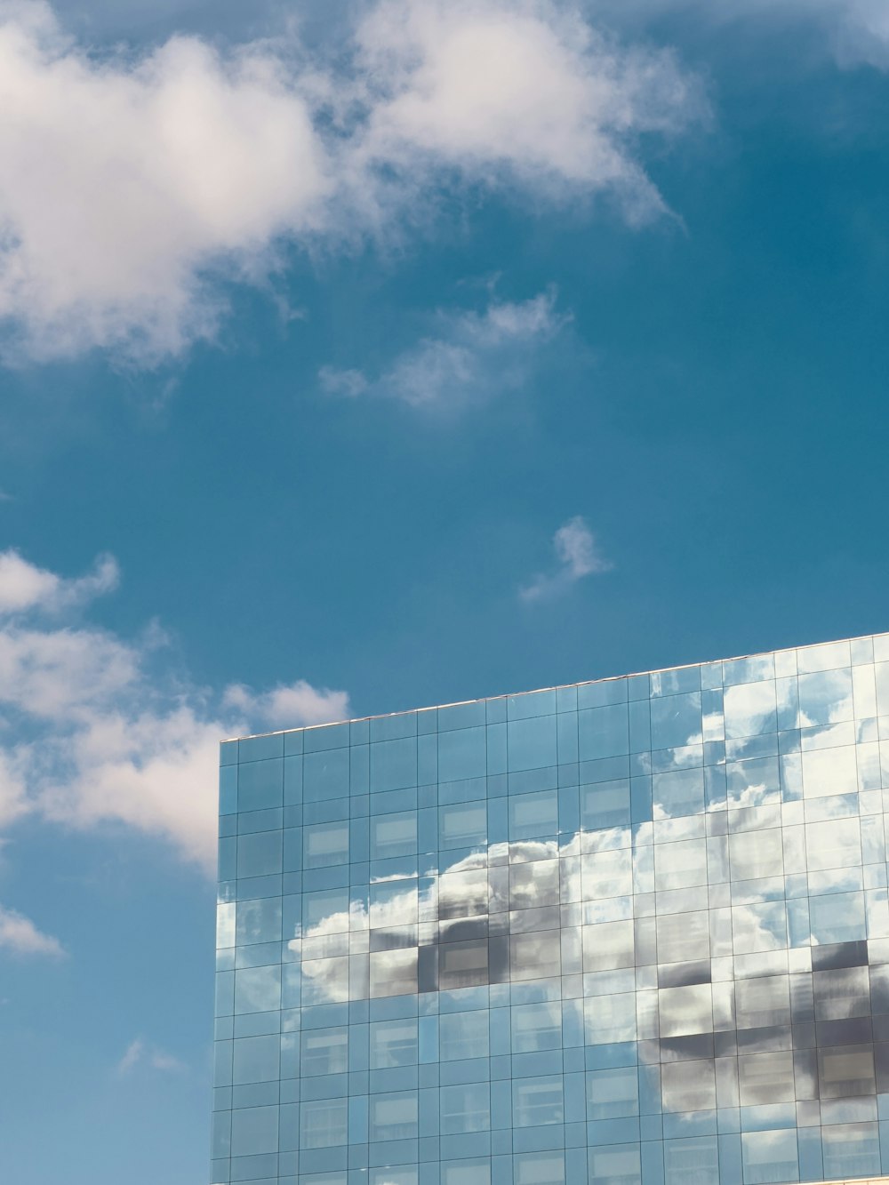 a building with a reflection of clouds in it