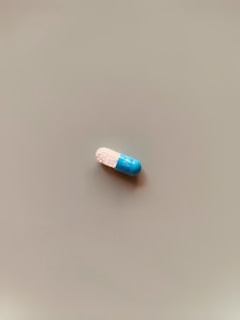 a blue and white pill sitting on top of a table
