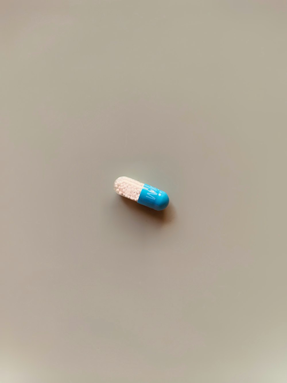 a blue and white pill sitting on top of a table