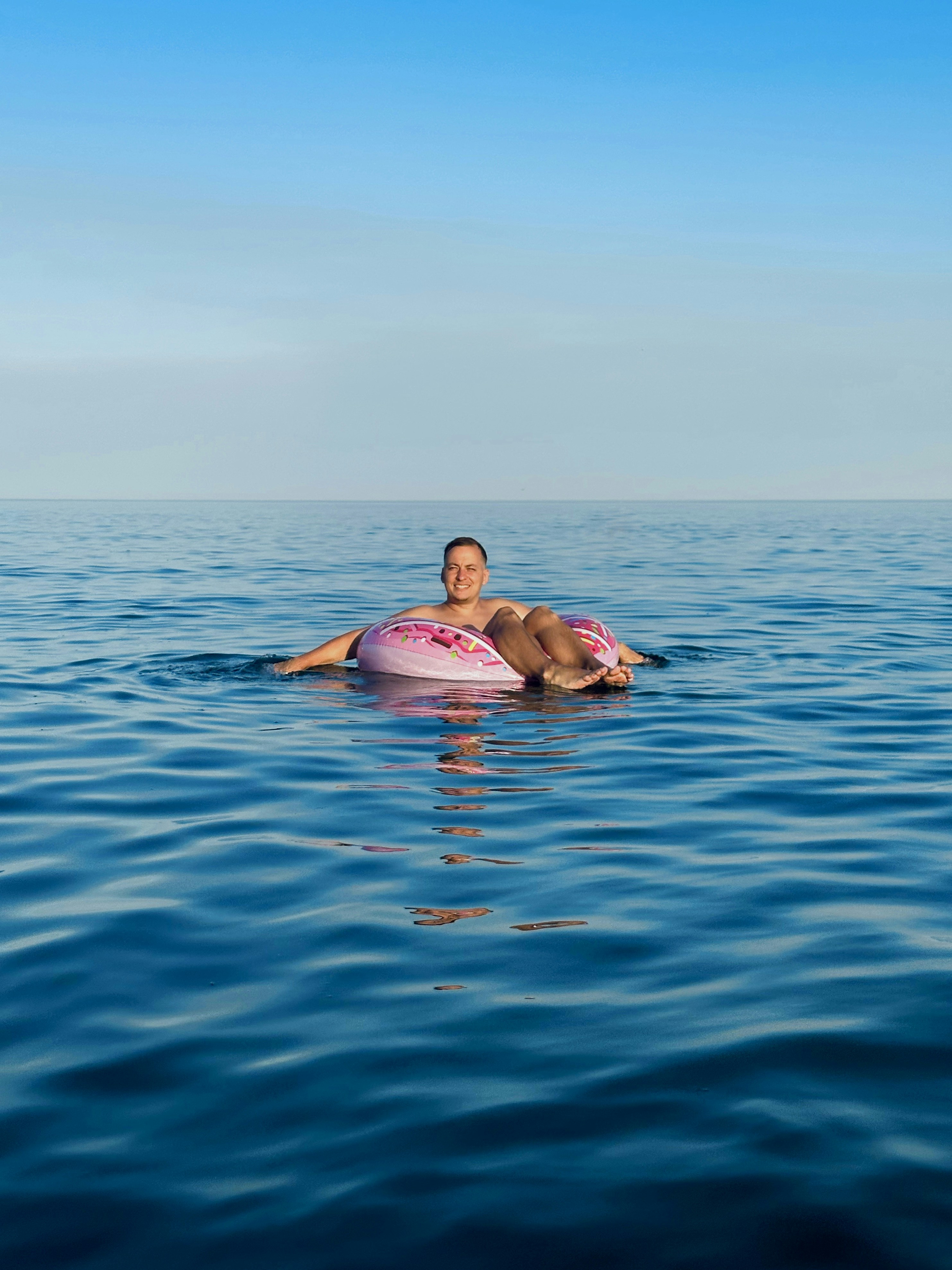 eine Frau, die auf einem Surfbrett mitten im Ozean liegt