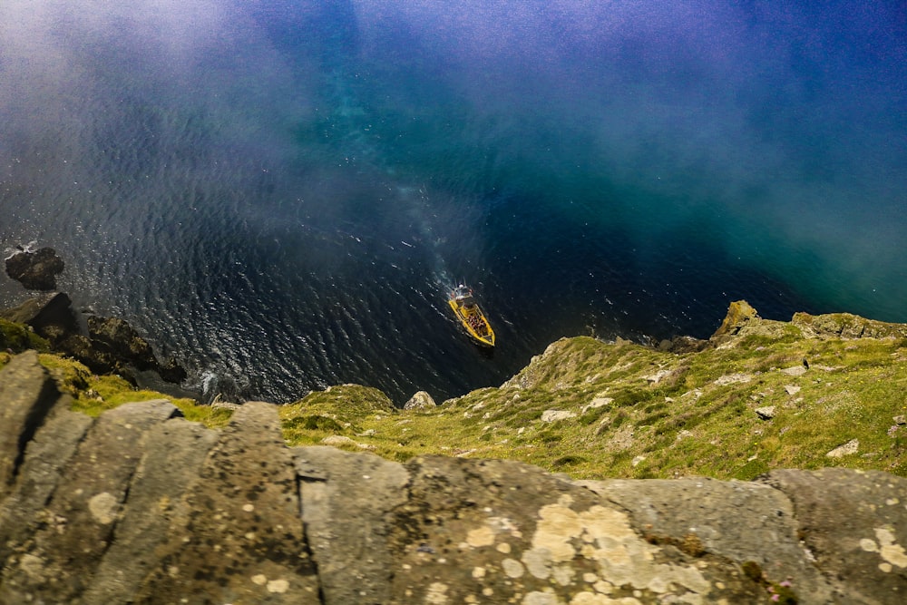 a boat in a body of water surrounded by rocks