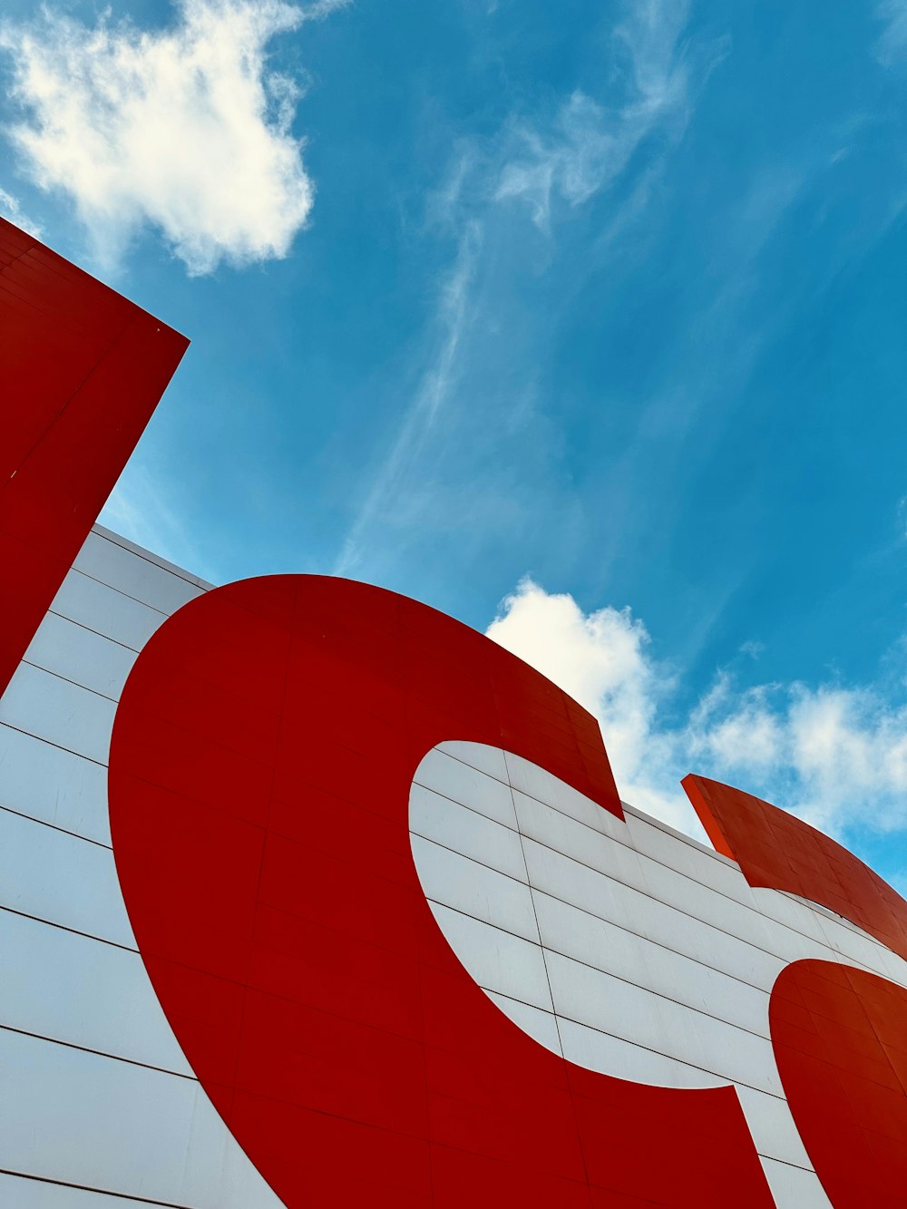 a red and white building with a blue sky in the background