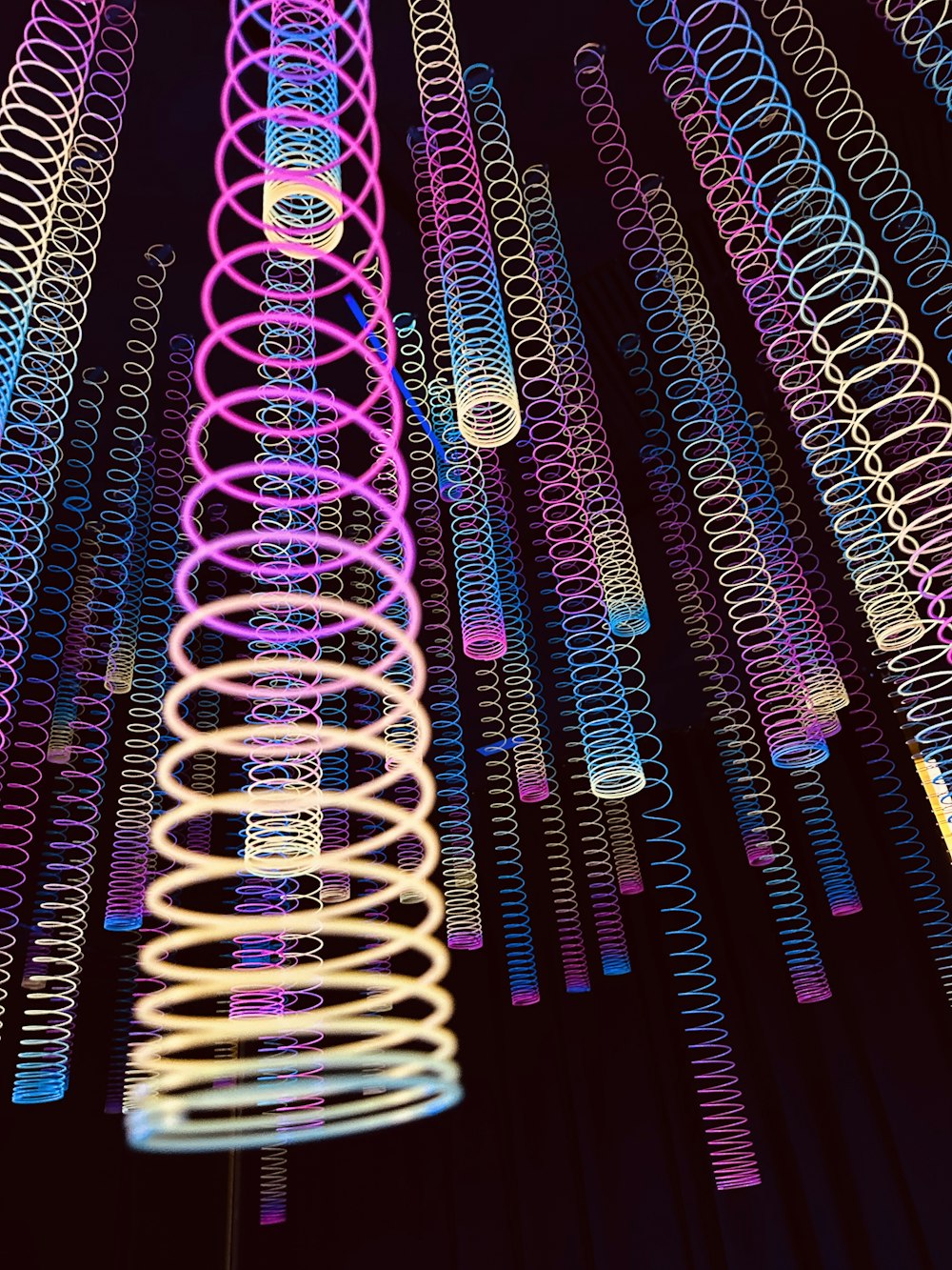 a bunch of colorful spirals hanging from a ceiling
