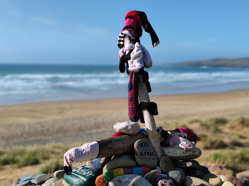 a pile of rocks on a beach with a santa hat on top