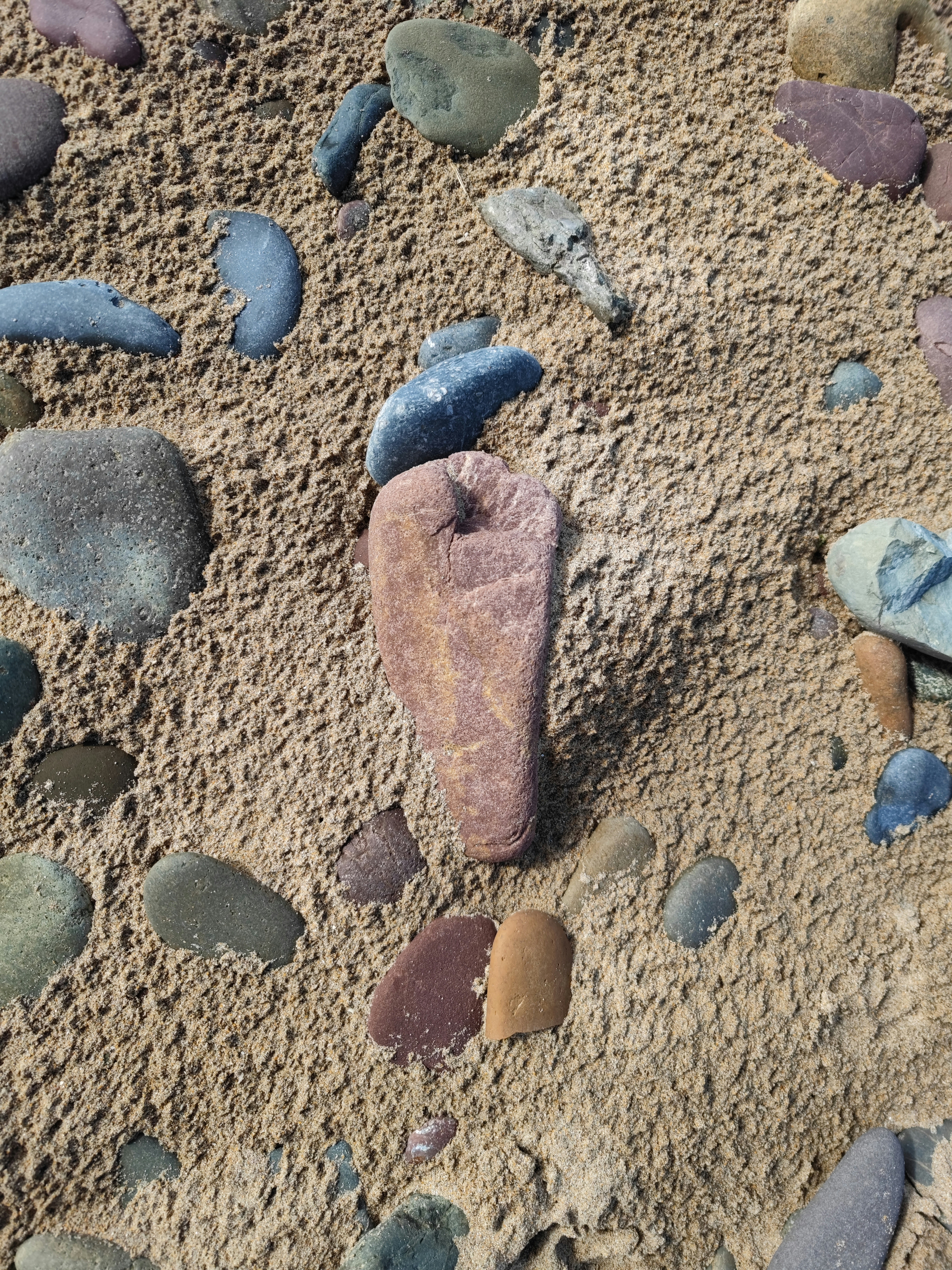 a rock in the middle of a sandy area
