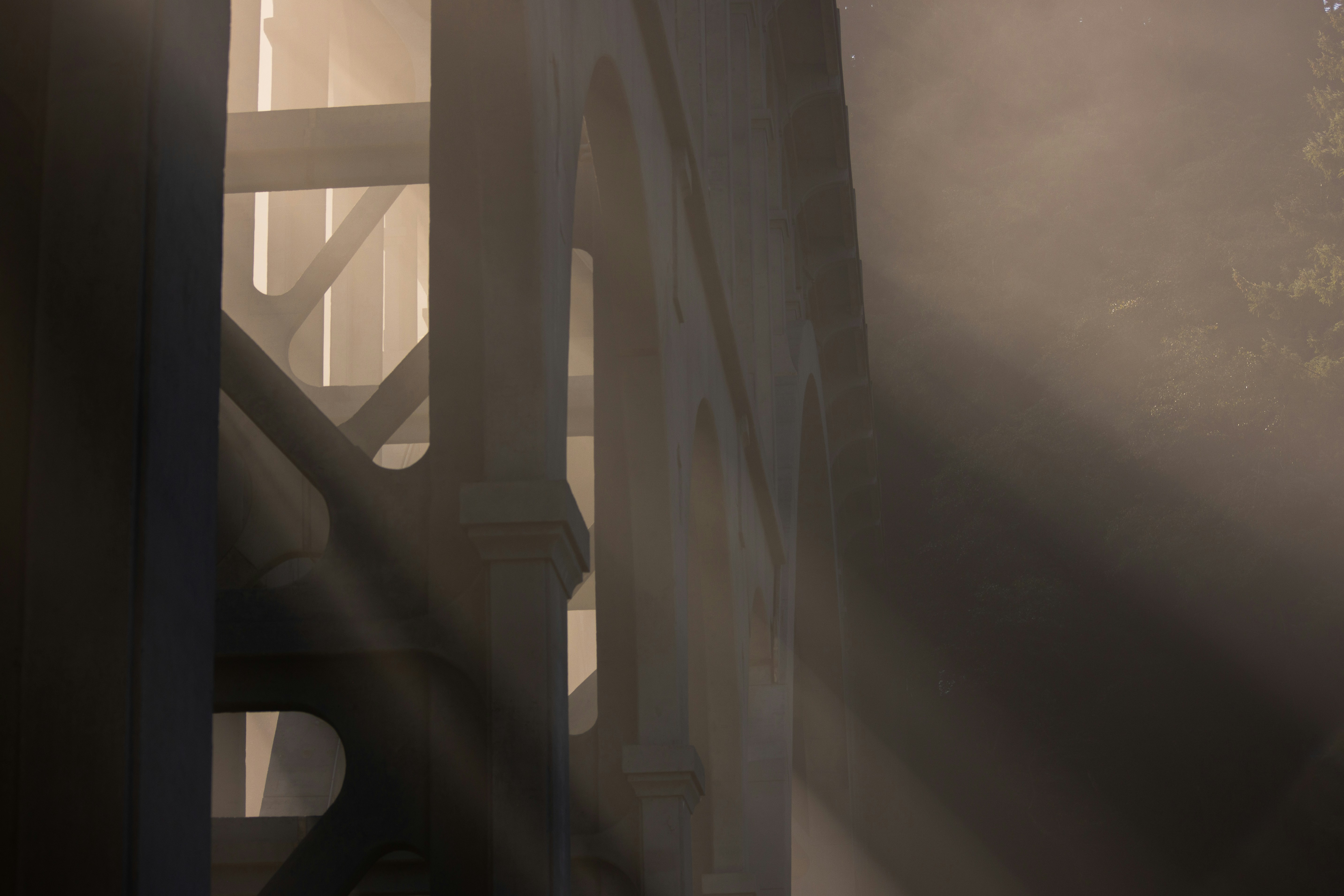 the sun is shining through the fog on a bridge, 