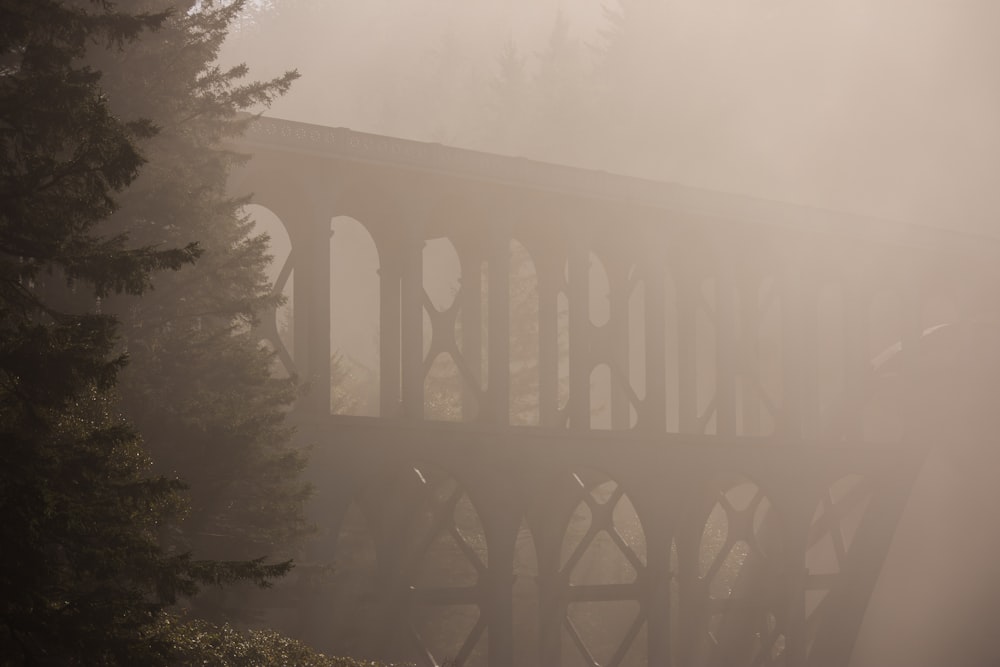 a foggy day with a train bridge in the background