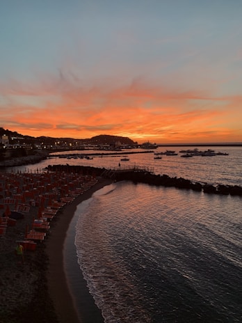 A vibrant beach sunset with colorful umbrellas and calm waves.